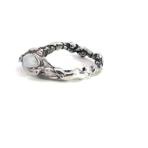 Side view of the rainbow moonstone setting and organic sterling silver band