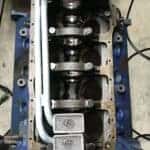 Valve train engine components on a workbench, part of custom automotive performance modification.