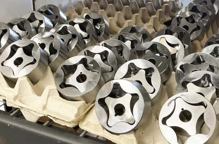 Metal engine piston components stored in foam packaging at Titan Speed Engineering manufacturing facility.