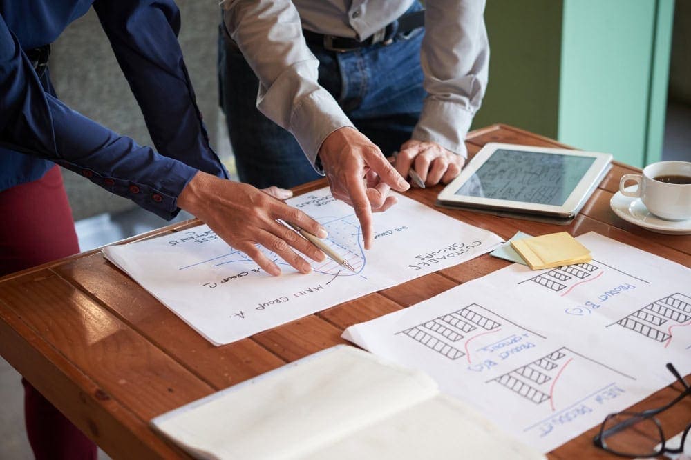 Expert discussing real estate development plans with Tony Tadros at a meeting table.