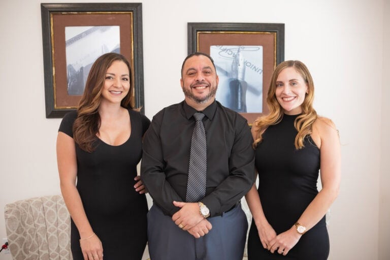 Elegant professional group photo of Tony Tadros with team, dental practice expert, smiling, confident, modern office background.