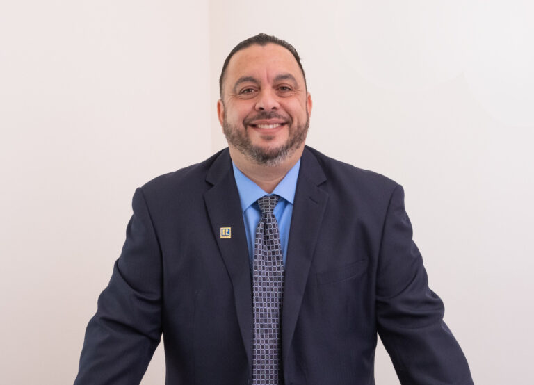 Tony Tadros, professional realtor, smiling in a business suit.