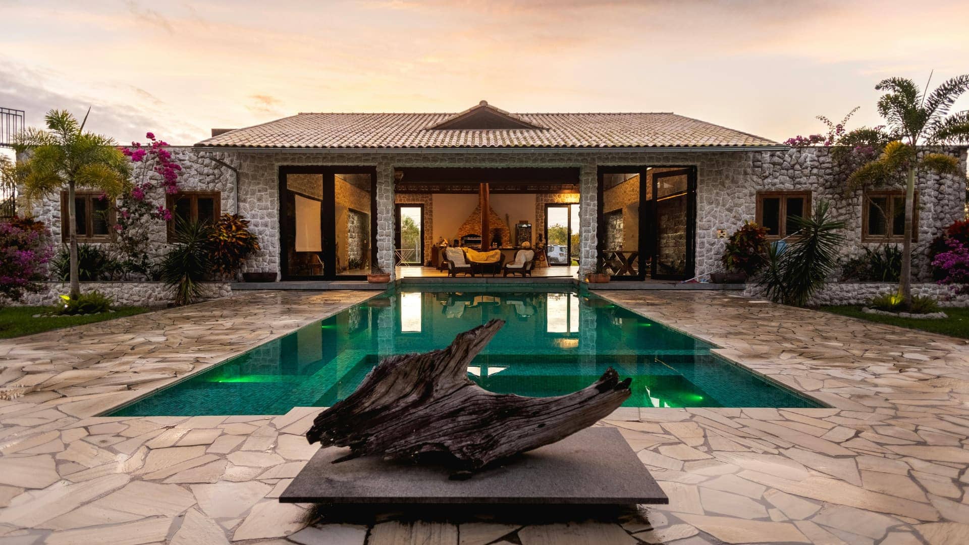 Luxury villa with pool, tropical plants, and outdoor living space.