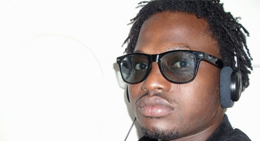 Homme portant lunettes et casque audio, regard sérieux.