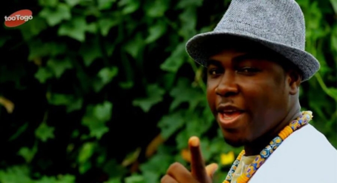 Homme togolais portant un chapeau gris et un collier coloré.