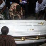 Cérémonie funéraire au Togo avec un cercueil blanc entouré de proches.