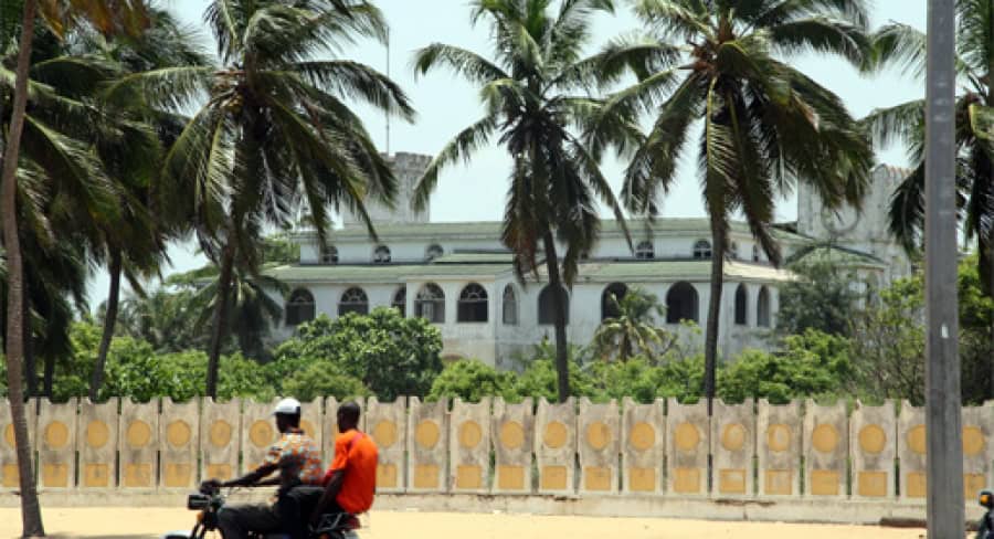 Bâtiment colonial historique entouré de palmiers au Togo.