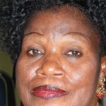Femme togolaise avec coiffure naturelle et bijoux traditionnels.
