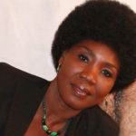 Femme togolaise avec coiffure afro et collier en perles.