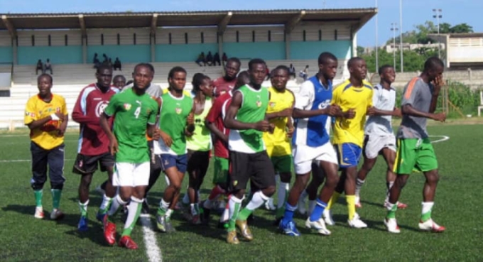 Groupe de joueurs de football togolais en séance d'entraînement sur le terrain.