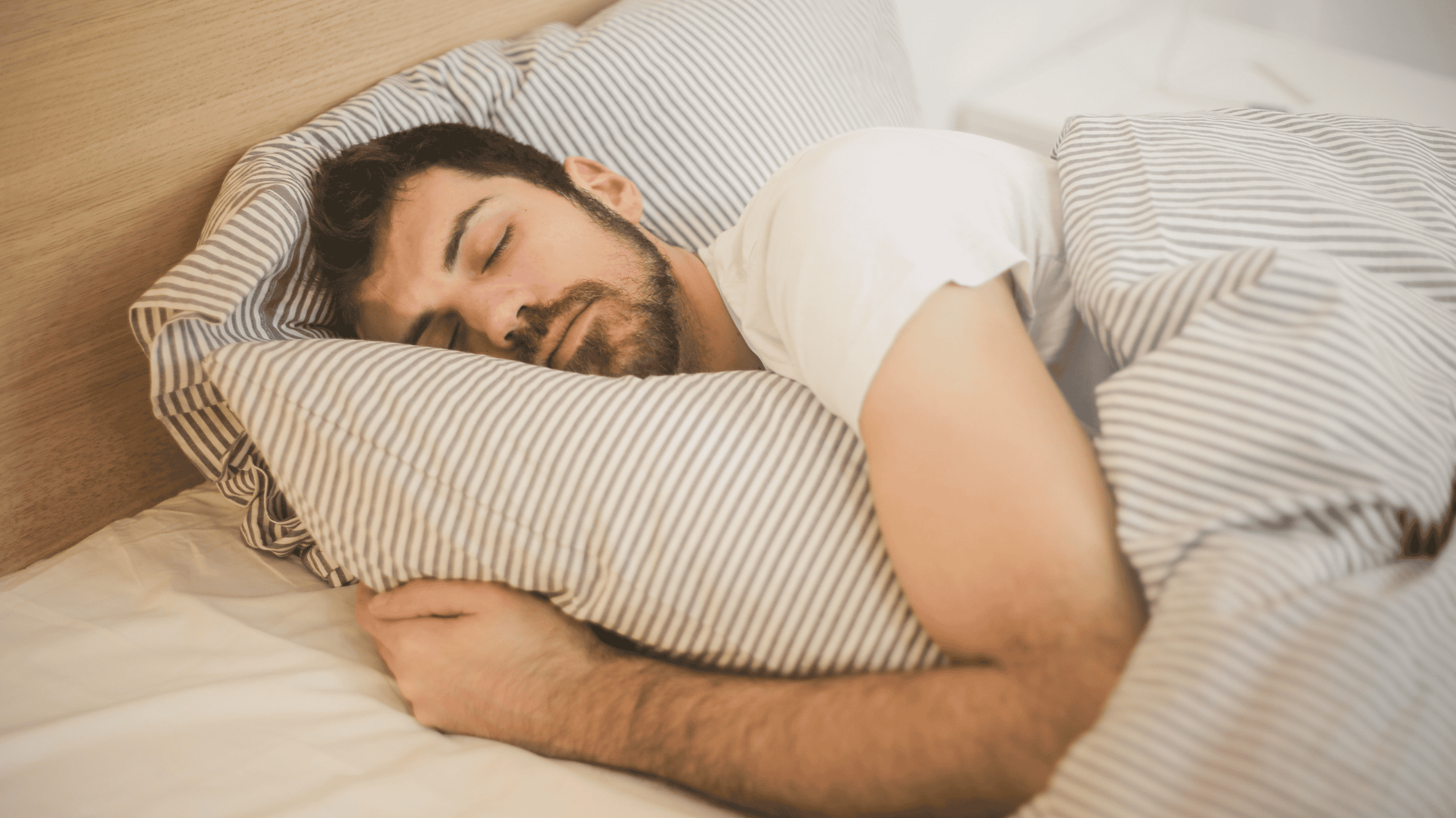 Man asleep in bed, illustrating the risks of sleeping in contact lenses