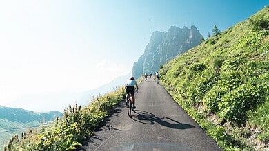 Cyclists climbing a paved mountain road during La Fausto Coppi