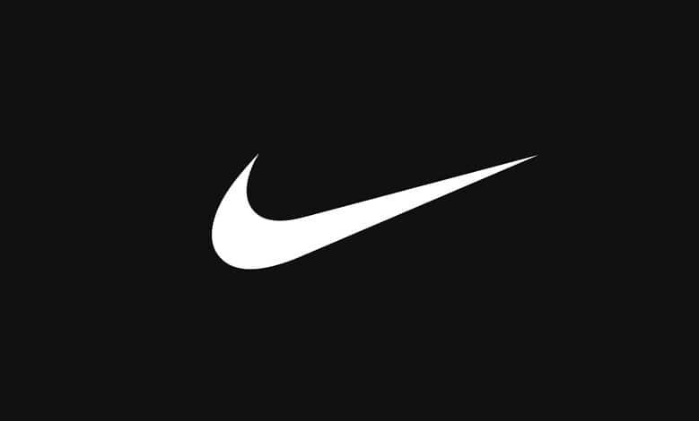 Close-up of the Nike swoosh logo on a black background, representing sportswear and athletic performance.