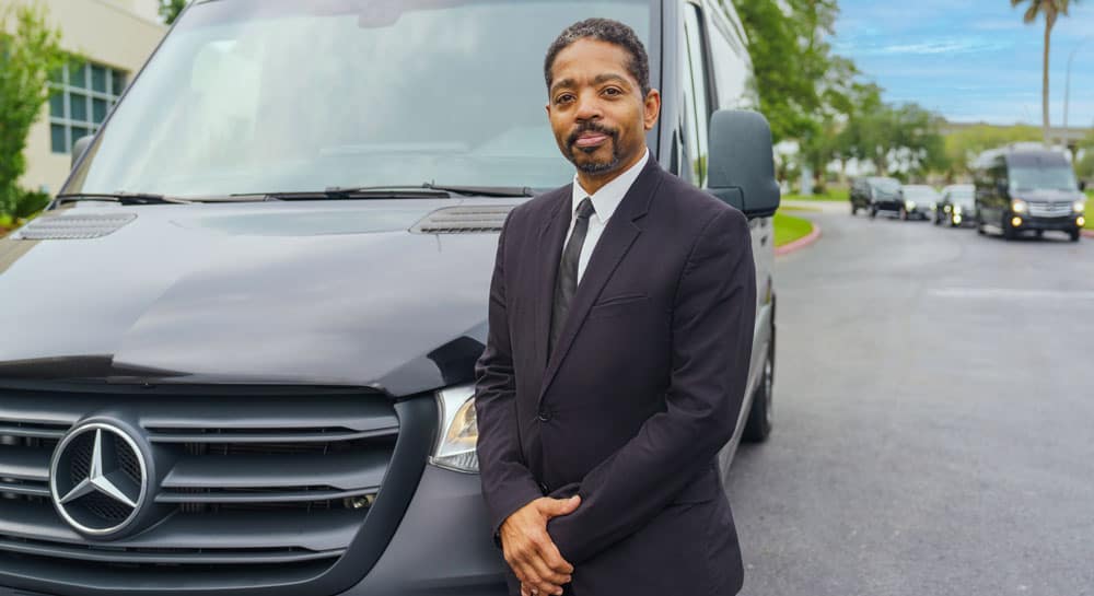 chauffeur standing next to mercedes sprinter van