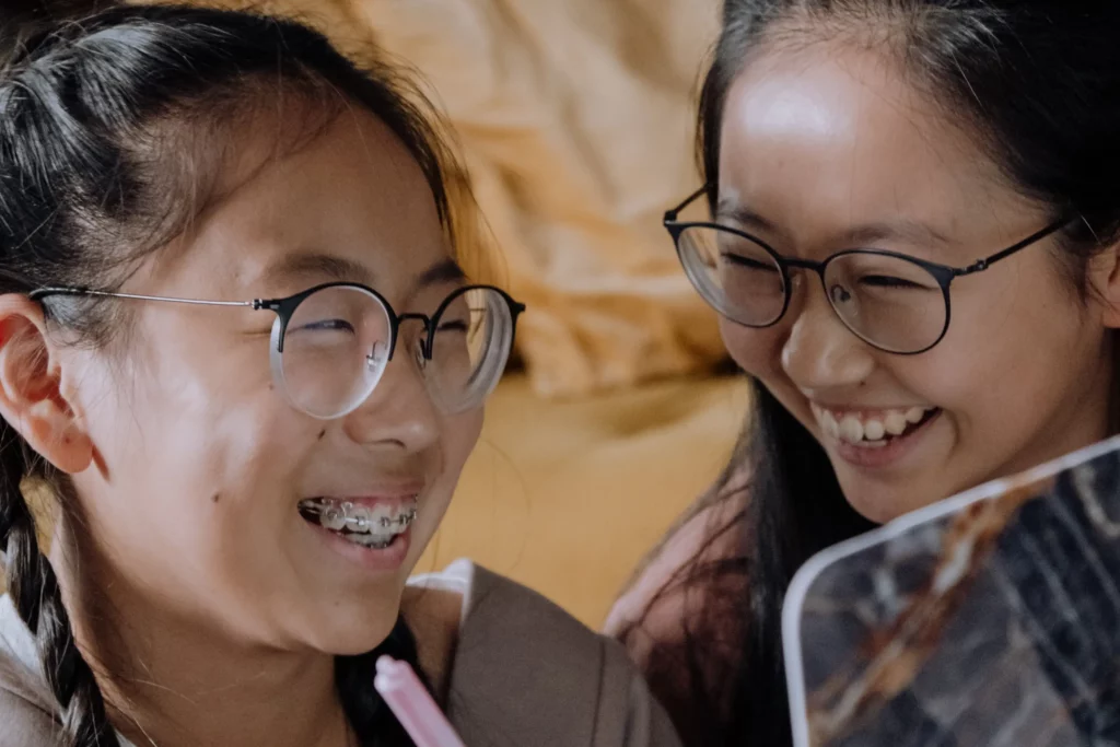 closeup shot of two girls wearing glasses ang laughing