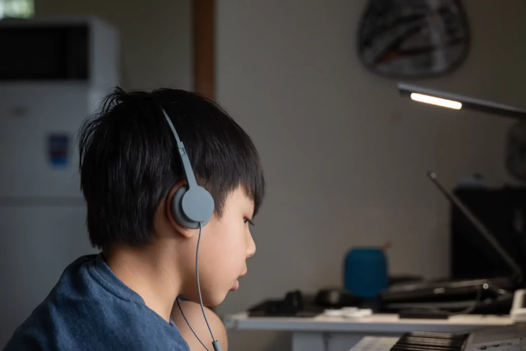 boy in blue crew neck shirt using grey headset listening to podcast