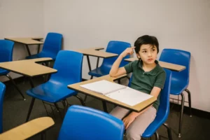 boy sitting on his desk thinking about productive things to do on holidays