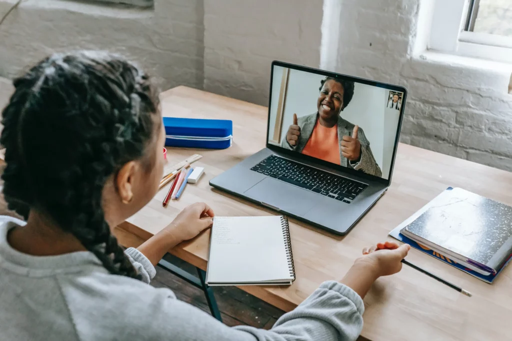 asian girl having video chat with teacher online on laptop