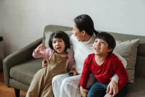 a woman and two children sitting on a couch showing gentle parenting