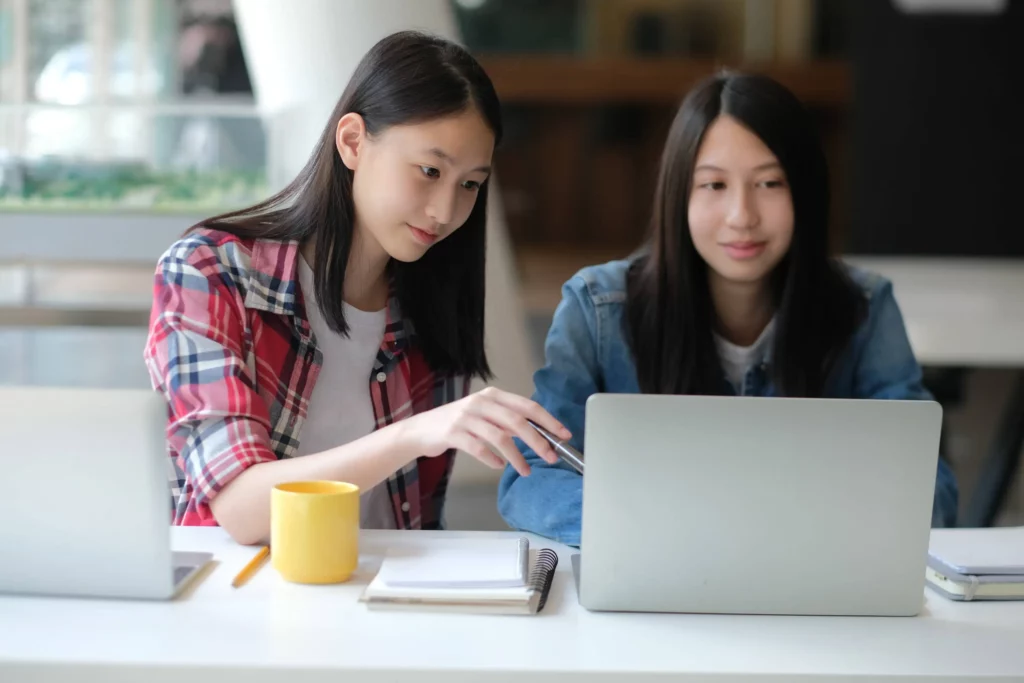 two female students reading lesson in laptop