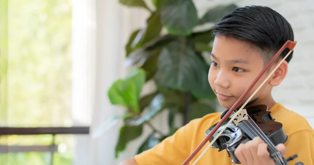 a boy playing violin in the living room | tuitioncentre SG
