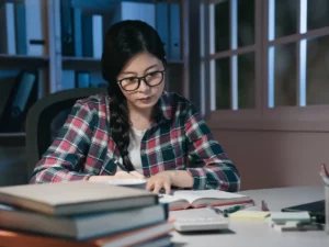 a person in glasses is working at their desk | tuitioncentre sg