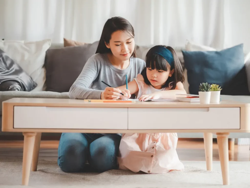 A mother and daughter doing homework in living room | tuitioncentre SG
