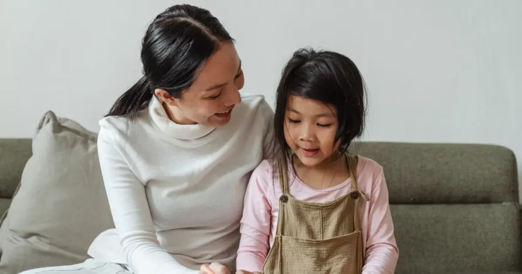 a woman and her daughter sitting on a couch | tuitioncentre sg