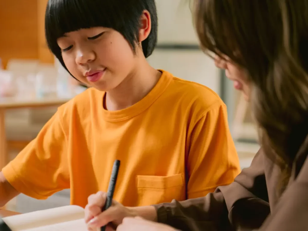 a woman and a young boy working on a laptop | tuitioncentre sg
