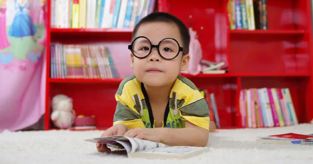 a child wearing glasses and reading a book | tuitioncentre sg
