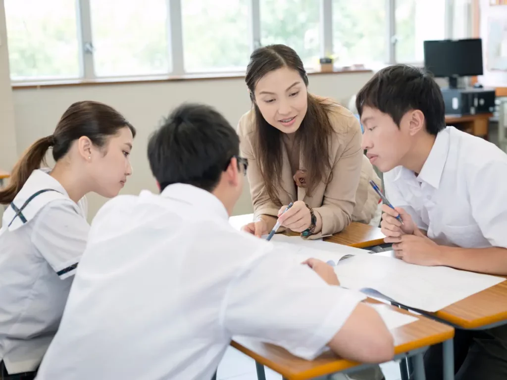 A woman teaching her students in a classroom | tuitioncentre sg