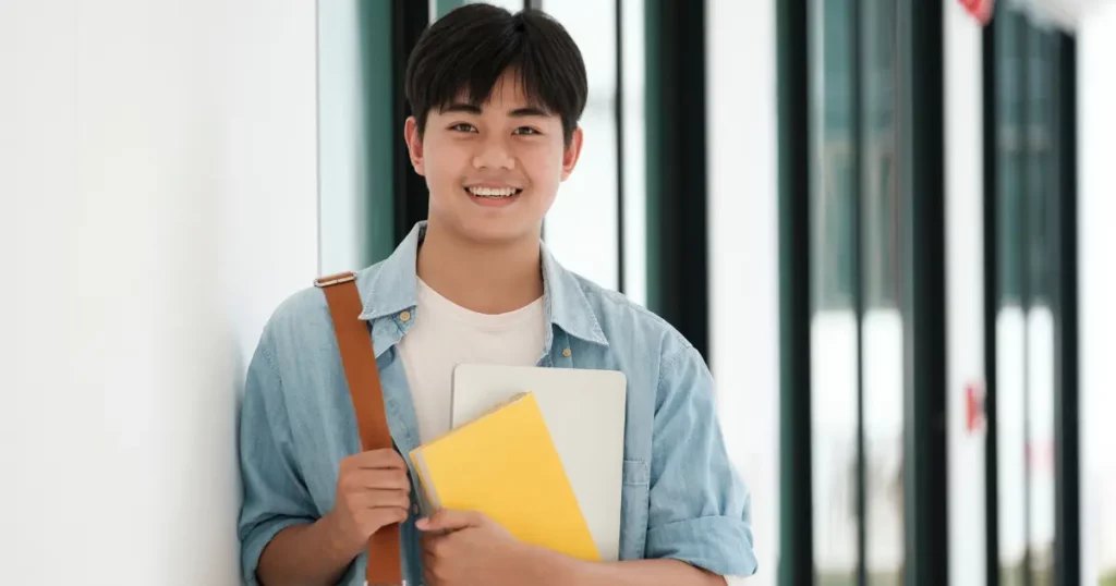 A student holding a folder and smiling | tuitioncentre sg
