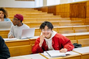 Students in a lecture hall, one smiling at camera | Tuition Centre SG