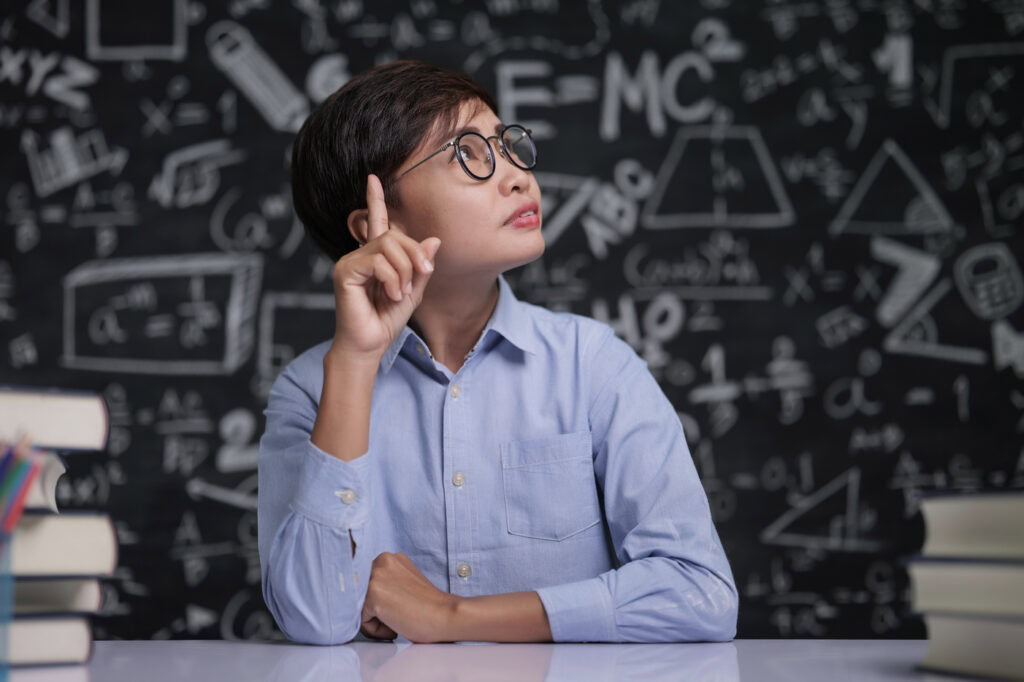 A student points his finger while thinking critically. | TCS