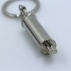 Silver metal muffler keychain with a realistic tailpipe design
