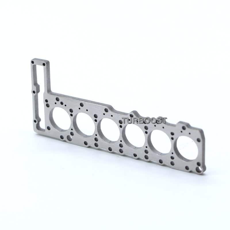 A silver 6-cylinder engine head gasket shaped keychain.