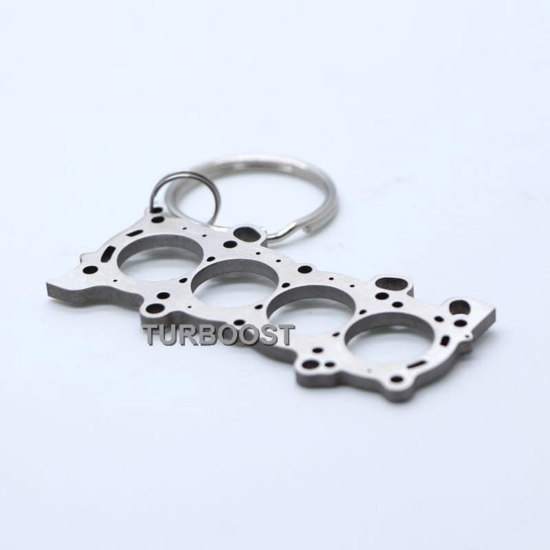 A silver Honda K-Series head gasket shaped stainless steel keychain.