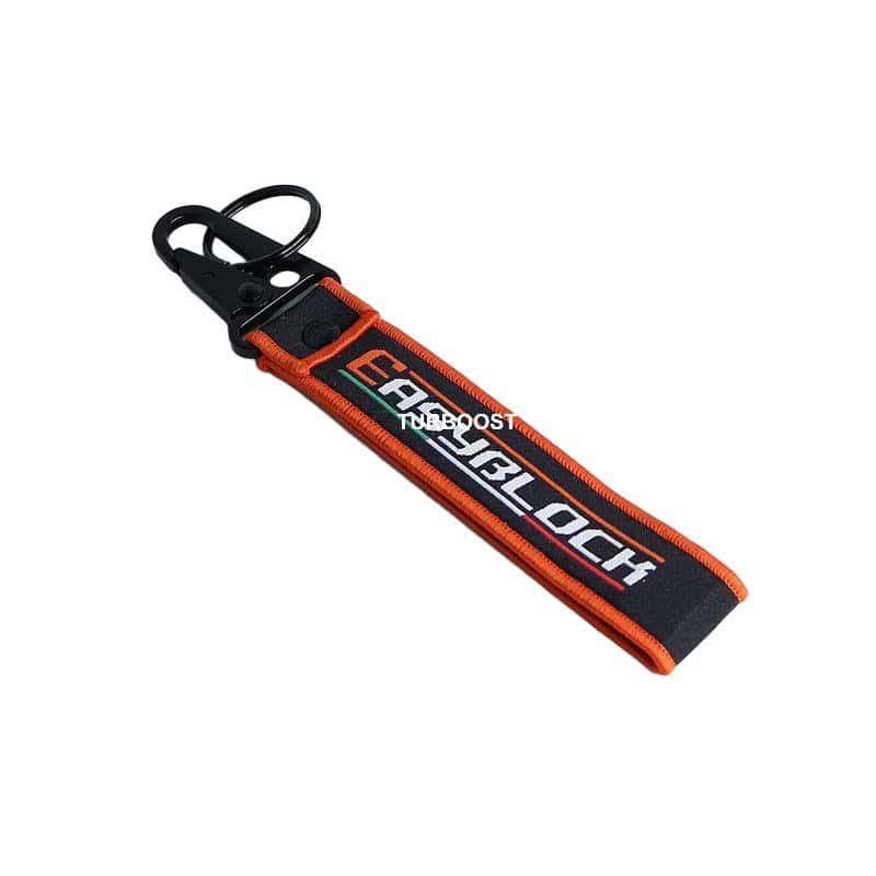 A black and orange woven keychain with a white "EASYBLOCK" embroidered logo, featuring a black eagle hook.