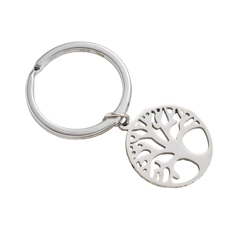 A round metal keychain with a cutout Tree of Life design and a silver key ring.