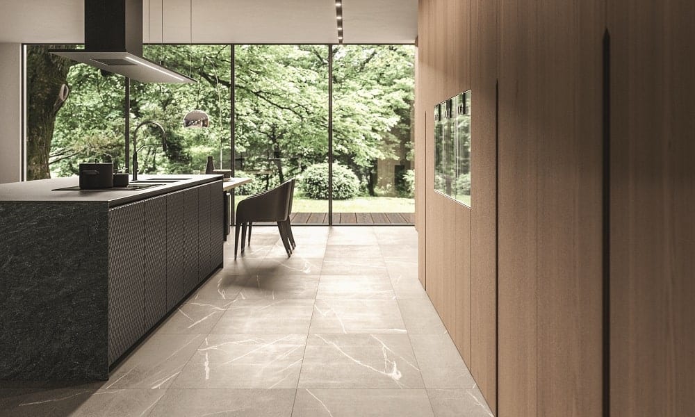 Bright modern kitchen with large windows overlooking lush greenery.