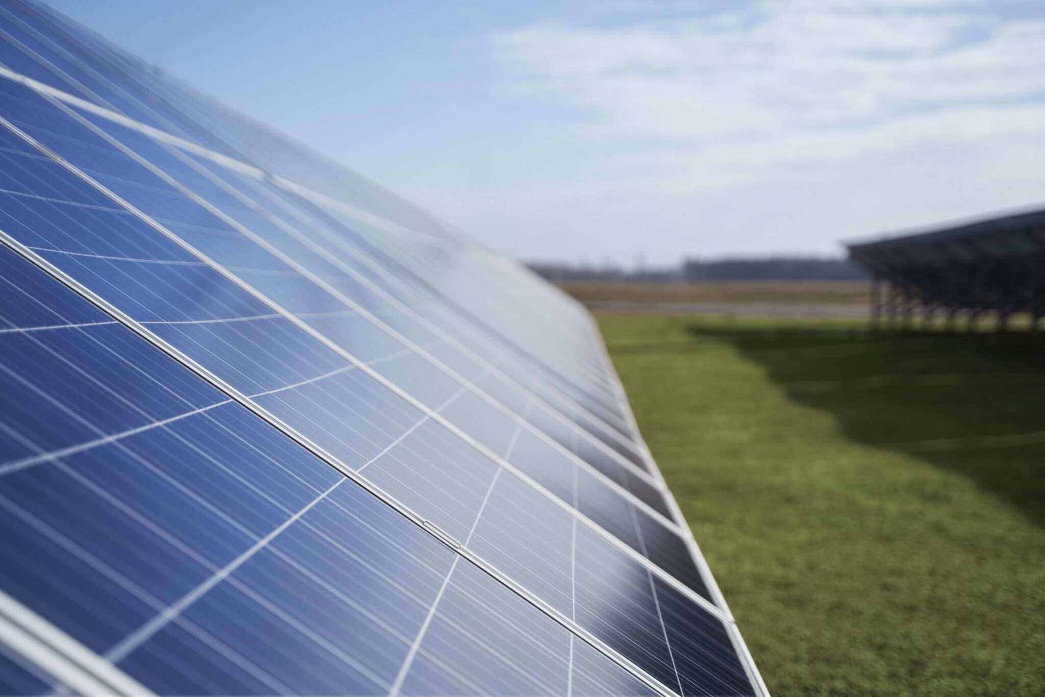 Napenergia szoláris panel, zöld mezőn, kék ég alatt.