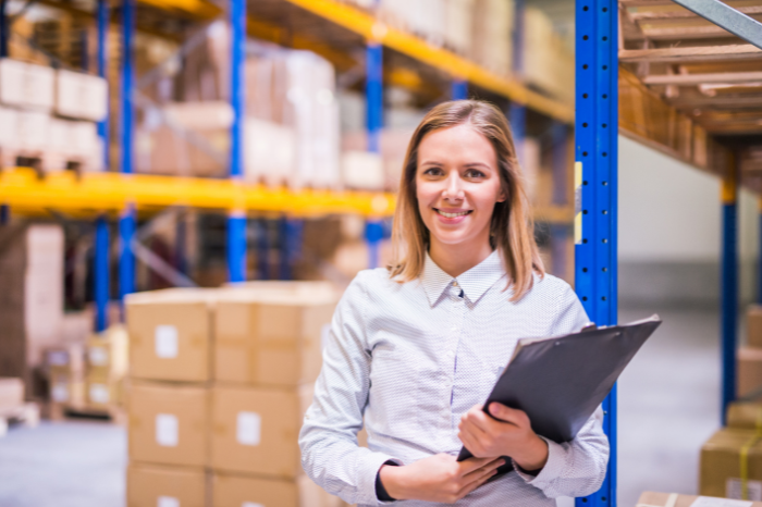 Woman in a warehouse with a clipboard