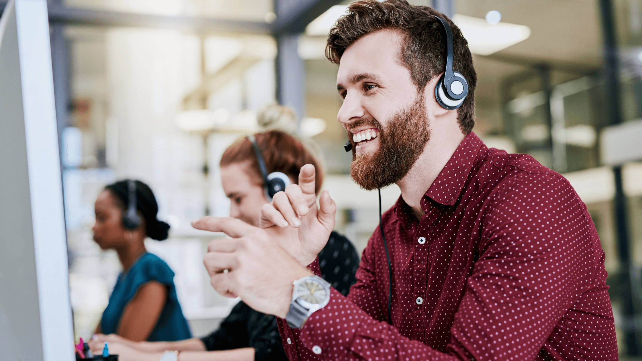 A smiling customer service representative with a headset, actively engaging with a computer screen, signifying effective uniform program management and dedicated uniform support services