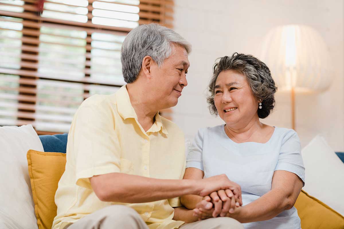 Happy and confident looking couple looking into each others eyes and holding hands