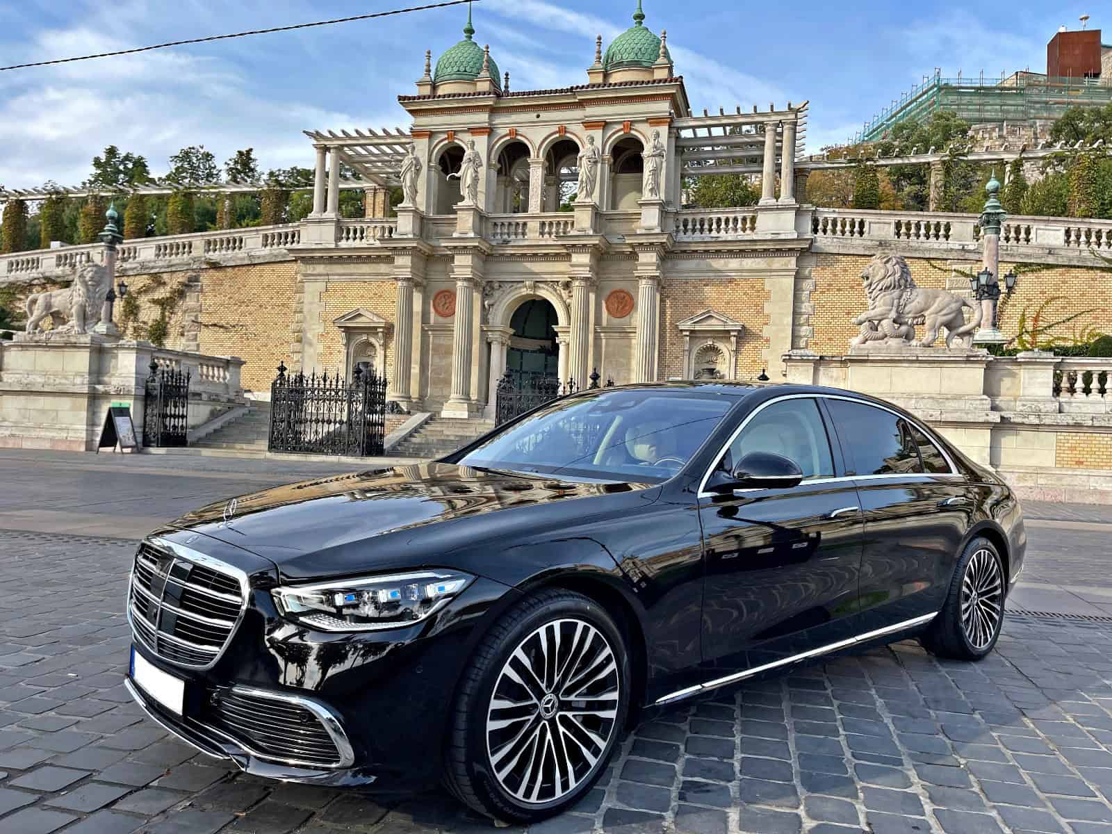 Luxury Mercedes sedan parked at Budapest palace, premium private airport transfer service Hungary