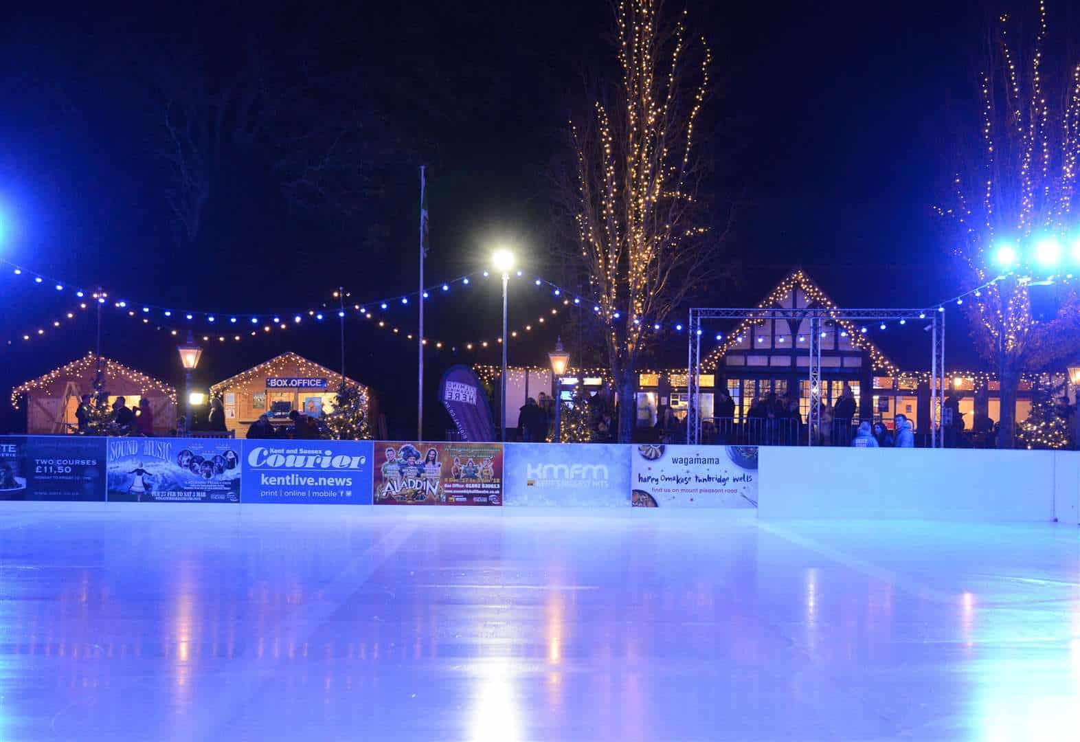 Colorful nighttime ice skating rink illuminated by string lights in Budapest.