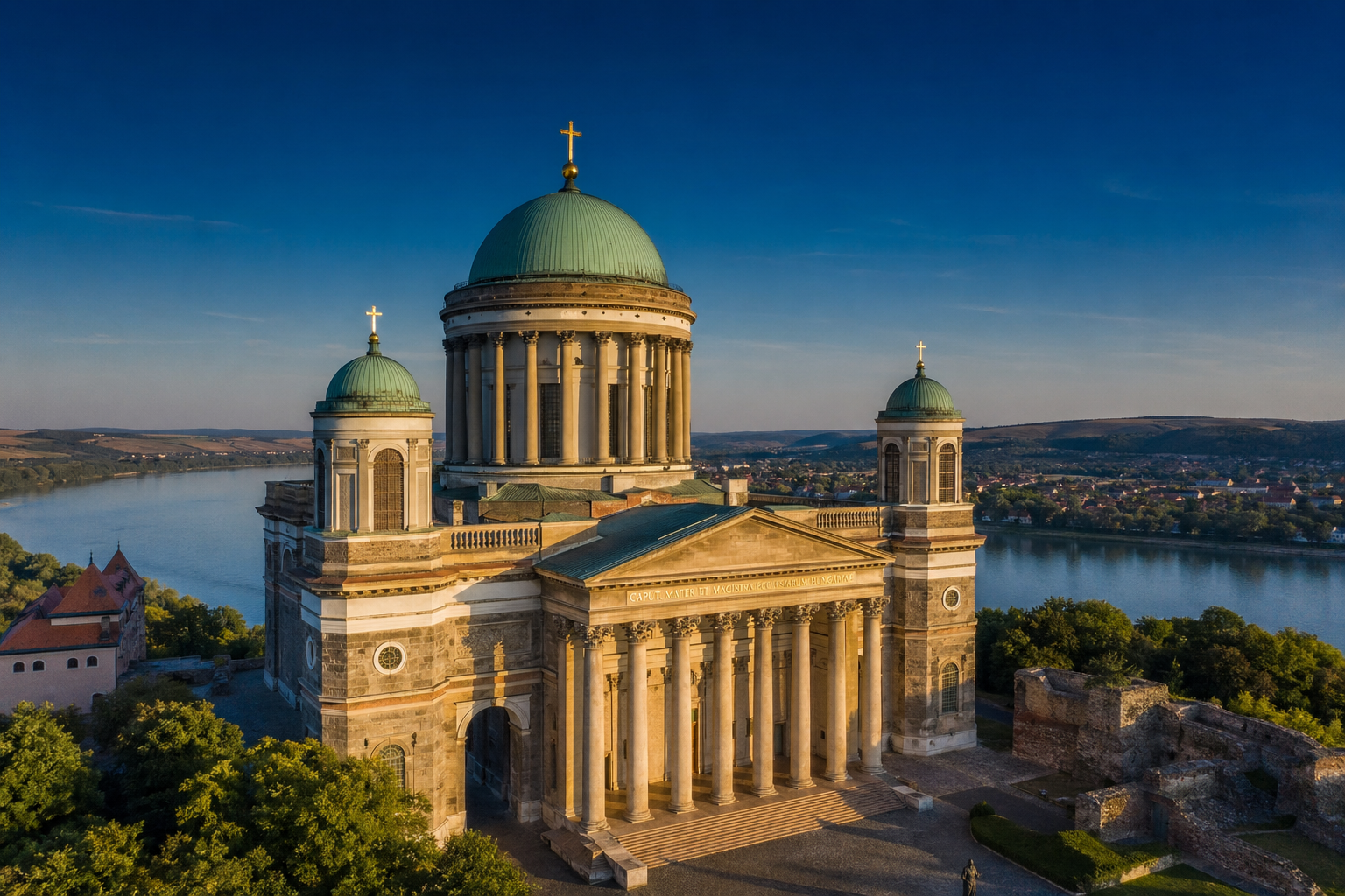 Église ancienne avec coupoles et colonnes surplombant un fleuve à Budapest.