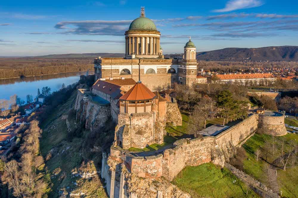 Esztergom Castle walls below the green dome of the Basilica, with the Danube behind.