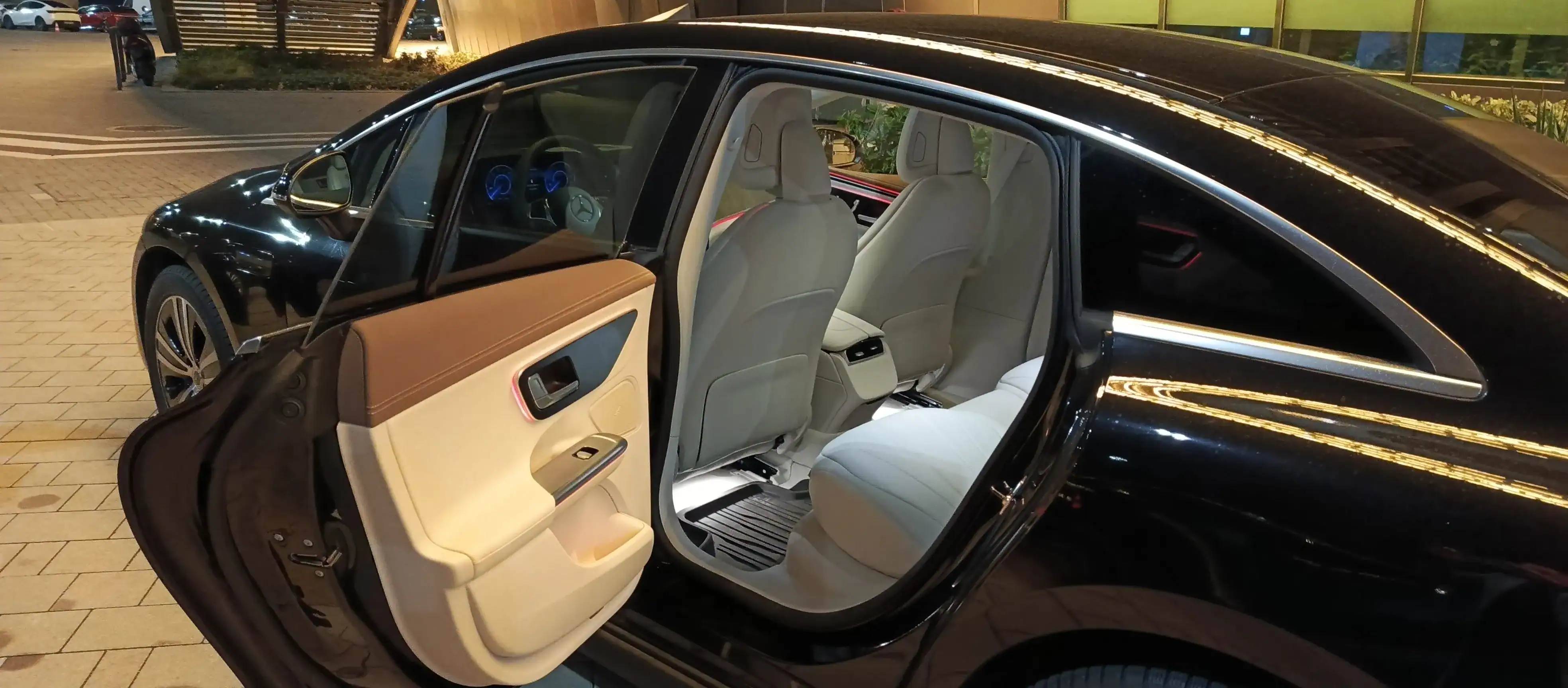 Intérieur de voiture privée avec la portière arrière ouverte, montrant des sièges spacieux et confortables.