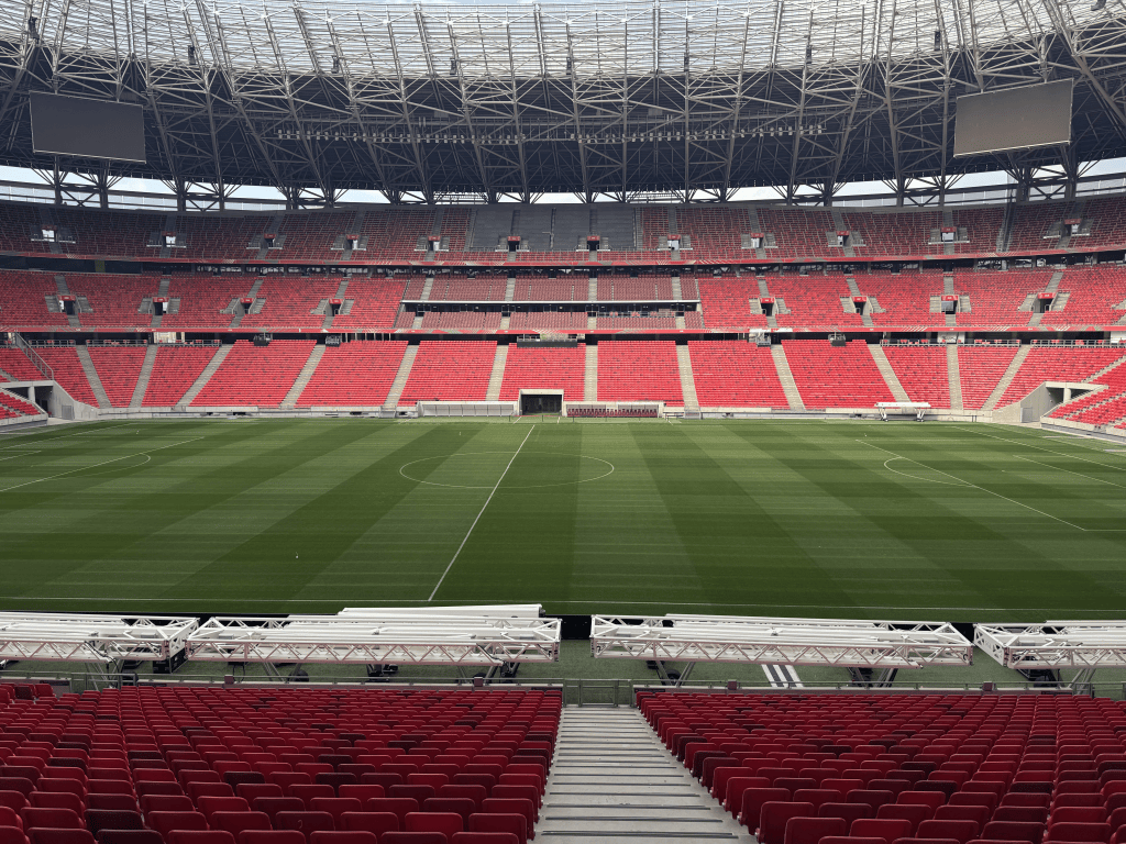 A central view of the Puskás Aréna pitch and opposite red stands.